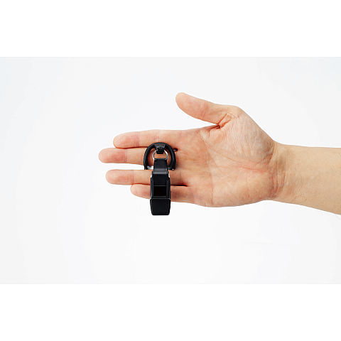 Une main tient un porte-clés noir avec boucle.
