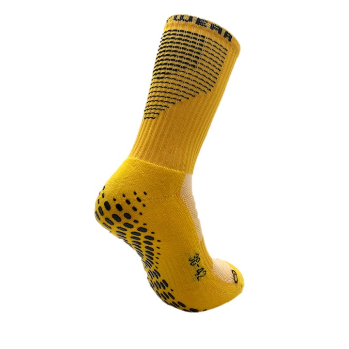 Eine gelbe Socke mit rutschfesten schwarzen Punkten und gestricktem Muster für sportliche Aktivitäten.