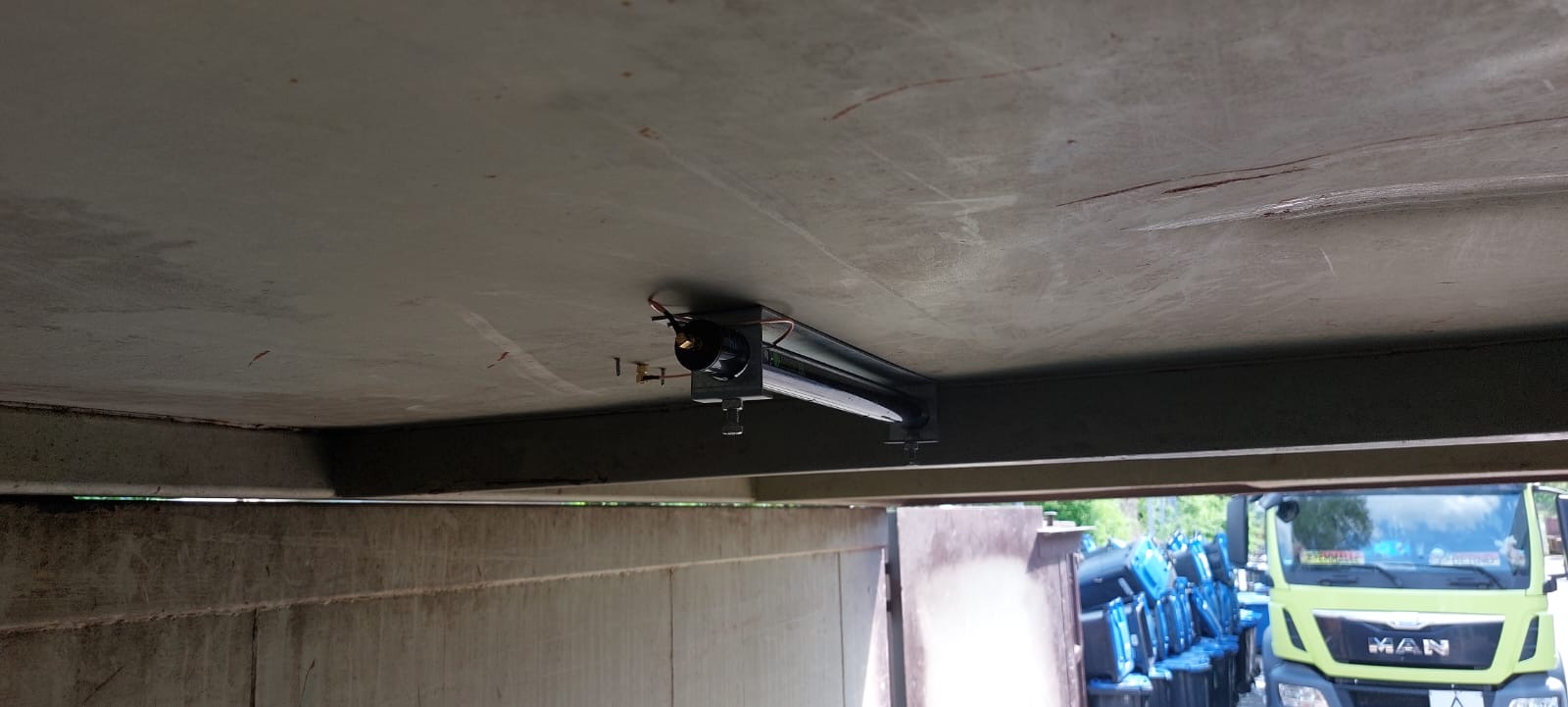 Deckenleuchte in einer Garage mit sichtbarem LKW im Hintergrund