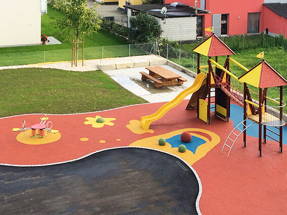 Bunt gestalteter Spielplatz mit Rutsche, Klettergerüst und kinderfreundlichem Bodenbelag